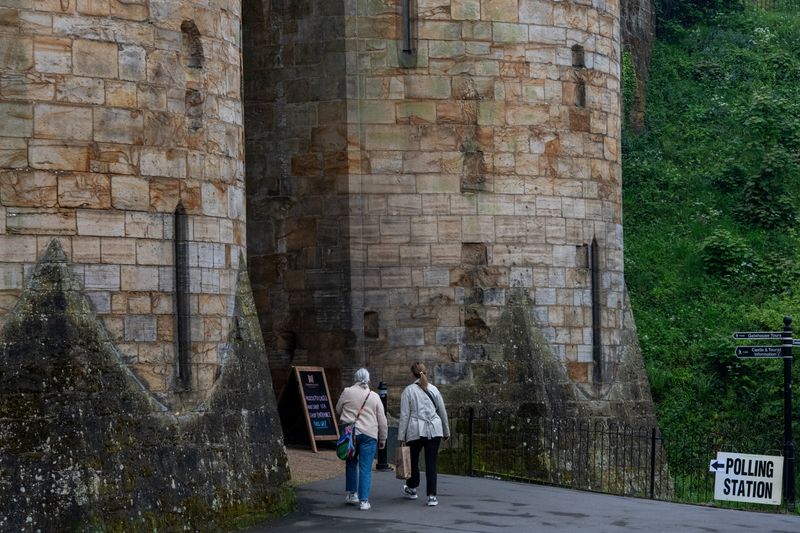 &copy; Reuters. People walk towards Tonbridge Castle, being used as a polling station during local elections in Tonbridge, Britain, May, 2, 2024. REUTERS/Chris J. Ratcliffe