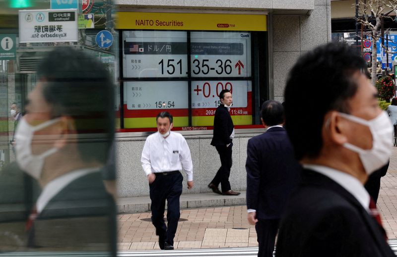 &copy; Reuters. مارة يسيرون بالقرب من شاشة إلكترونية بأحد مكاتب السمسرة في طوكيو تعرض سعر صرف الين الياباني مقابل الدولار الأمريكي يوم 28 مارس آذار 2024. تصوير