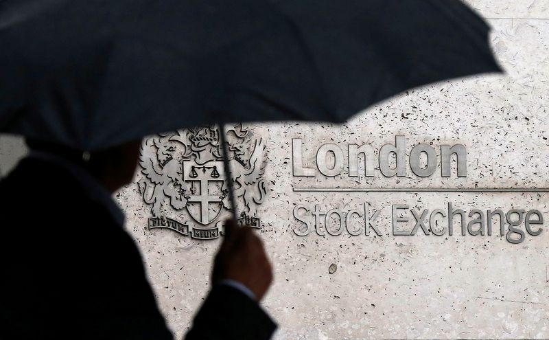 &copy; Reuters. FILE PHOTO: A man shelters under an umbrella as he walks past the London Stock Exchange in London, August 24, 2015. REUTERS/Suzanne Plunkett/File Photo