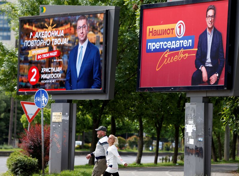 © Reuters. People walk past campaign billboards for the upcoming parliament and presidential elections in Skopje, North Macedonia May 3, 2024. REUTERS/Ognen Teofilovski