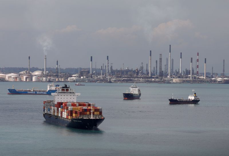 © Reuters. A container ship passes Shell's Pulau Bukom refinery in Singapore November 17, 2020.  REUTERS/Edgar Su/ File Photo
