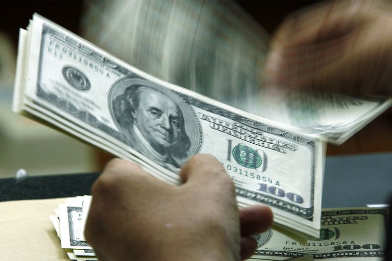 &copy; Reuters. Une personne compte des billets en dollars américains. /Photo prise le 22 août 2005/REUTERS/Beawiharta BEA/DY