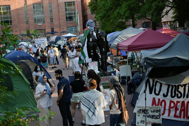 &copy; Reuters. FILE PHOTO: People stand around a statue of George Washington tied with a Palestinian flag and a keffiyeh inside a pro-Palestinian encampment at George Washington University in Washington, DC, U.S., May 2, 2024. REUTERS/Craig Hudson/File Photo