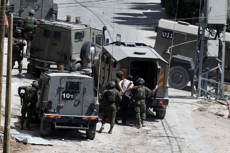&copy; Reuters. جنود إسرائيليون يعتقلون فلسطينيا خلال مداهمة في بلدة دير الغصون بالضفة الغربية يوم الرابع من مايو أيار 2024. تصوير: رنين صوافطة - رويترز