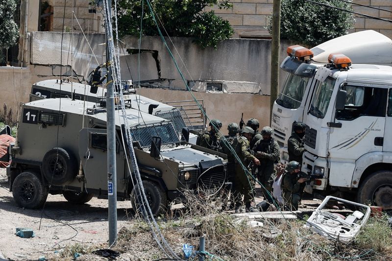 &copy; Reuters. De nombreux soldats israéliens arrêtent un homme palestinien lors d'un raid en Cisjordanie occupée. /Photo prise le 4 mai 2024/REUTERS/Raneen Sawafta