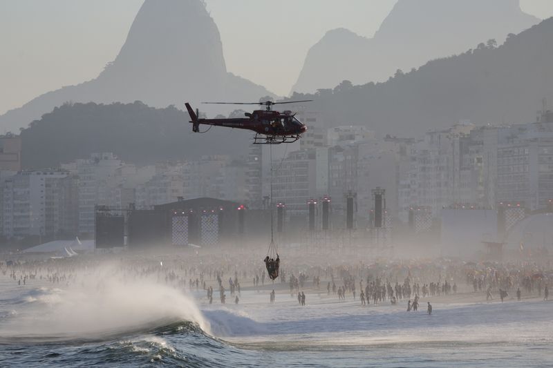 &copy; Reuters. A helicopter transports lifeguards and a rescued person as people gather at Copacabana beach near the stage where Madonna will hold a concert, in Rio de Janeiro, Brazil May 4, 2024. REUTERS/Ricardo Moraes