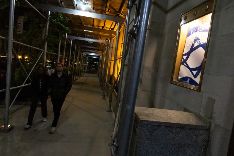 © Reuters. شخصان يسيران بجوار معبد يهودي أُخلي في وقت سابق من اليوم بعد تلقيه تهديد بوجود قنبلة في مدينة نيويورك يوم الرابع من مايو أيار 2024. تصوير: كارلوس باريا - رويترز