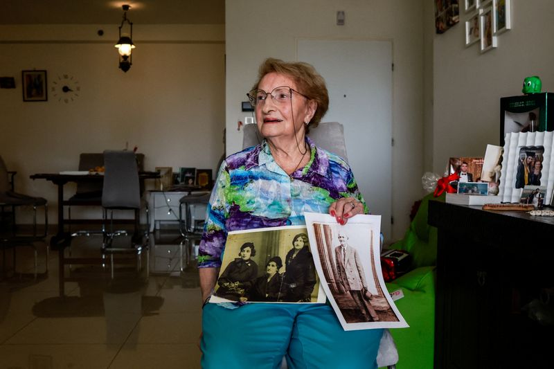 &copy; Reuters. Holocaust survivor, Sarina Blumenfeld, 89, who endures flashbacks from the horrors of her past and now struggles to process the carnage following a deadly infiltration by Hamas gunmen, shows black and white photos during an interview with Reuters in her h