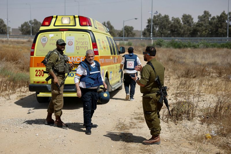 &copy; Reuters. Des soldats israéliens et des médecins marchent près d'une ambulance après que le groupe islamiste palestinien Hamas a revendiqué une attaque au point de passage de Karem Shalom, près de la frontière israélienne avec Gaza, dans le sud d'Israël. /