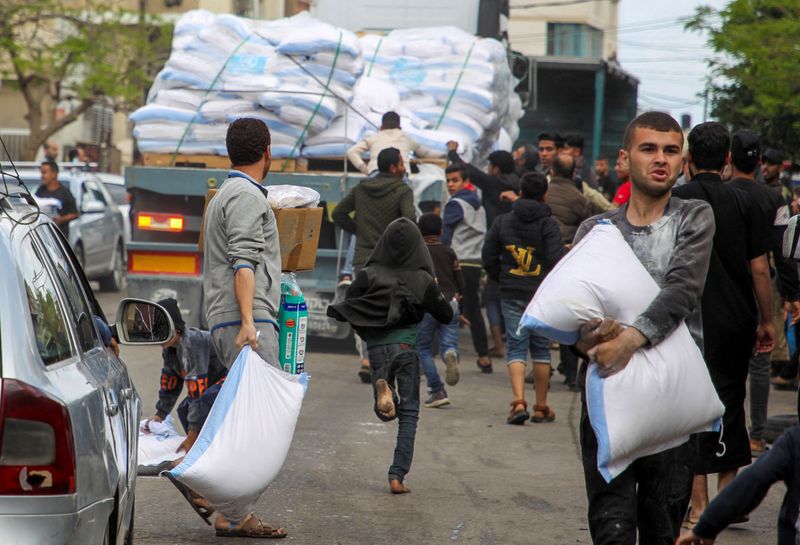 &copy; Reuters. Pessoas pegam sacos de farinha de um caminhão em Rafah
 6/5/2024   REUTERS/Hatem Khaled 