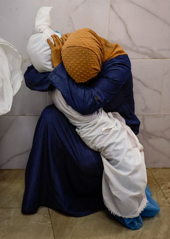 &copy; Reuters. Num abraço final, Inas Abu Maamar, 36 anos, embala o corpo já envolto de sua sobrinha de cinco anos, Saly,  no necrotério do Hospital Nasser, no sul de Gaza. A foto venceu prêmio Pulitzer de fotografia de notícias de última hora
17/10/2023
REUTERS/M
