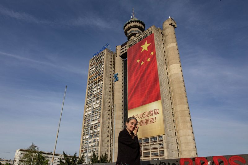 &copy; Reuters. FILE PHOTO: A woman passes by a Chinese flag hanging from a building ahead of President Xi Jinping's visit in Belgrade, Serbia, May 6, 2024. REUTERS/Marko Djurica/File Photo
