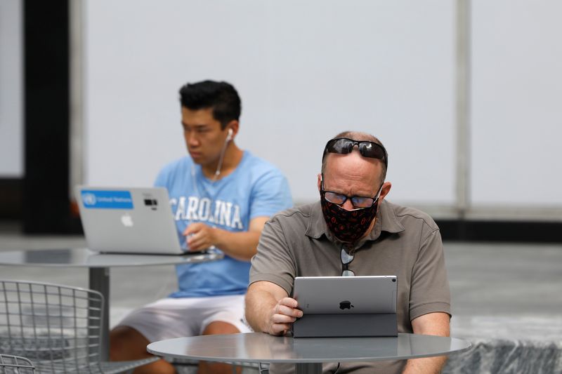 &copy; Reuters. People use an Apple laptop computer and an Apple iPad in Manhattan, New York City, U.S., August 25, 2020. REUTERS/Andrew Kelly/File Photo