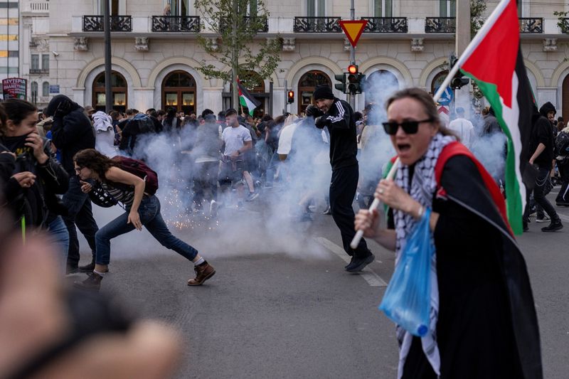 © Reuters. Palestinians and pro-Palestinian demonstrators run to avoid tear gas during clashes with riot police as they were protesting outside the Egyptian embassy, amid the ongoing conflict between Israel and the Palestinian Islamist group Hamas, in Athens, Greece, May 7, 2024. REUTERS/Alkis Konstantinidis