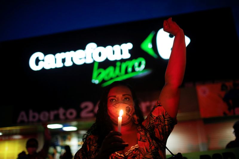 &copy; Reuters. A woman holds a candle during a protest in front of a Carrefour supermarket in Brasilia, Brazil, after Joao Alberto Silveira Freitas was beaten to death by security guards at a Carrefour supermarket in Porto Alegre, November 26, 2020. REUTERS/Adriano Mach
