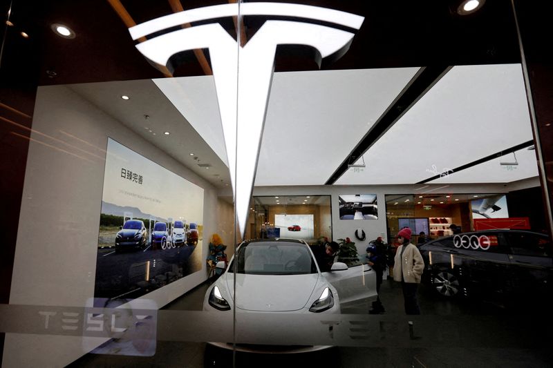 © Reuters. FILE PHOTO: Khách tham quan kiểm tra một chiếc ô tô Tesla Model 3 bên cạnh một chiếc Model Y được trưng bày tại phòng trưng bày của nhà sản xuất xe điện (EV) Hoa Kỳ ở Bắc Kinh, Trung Quốc ngày 4 tháng 2 năm 2023. REUTERS/Florence Lo/File Photo