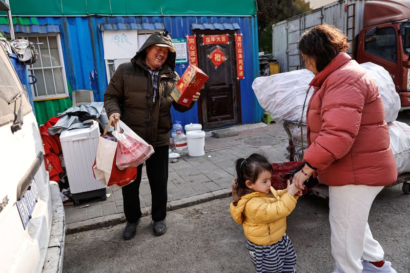 &copy; Reuters. Wu Yonghou, 58, receives presents from a resident on Chinese Lunar New Year's Eve, at the recycling station where he and his wife work, in Beijing, China February 9, 2024. REUTERS/Tingshu Wang