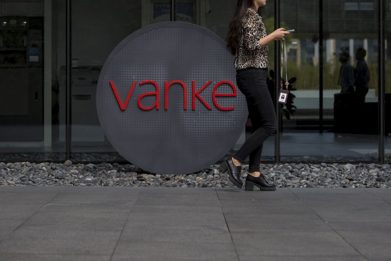 &copy; Reuters. FILE PHOTO: An employee walks past a logo of Vanke at its headquarters in Shenzhen, south China's Guangdong province, November 2, 2015. REUTERS/Tyrone Siu/File Photo