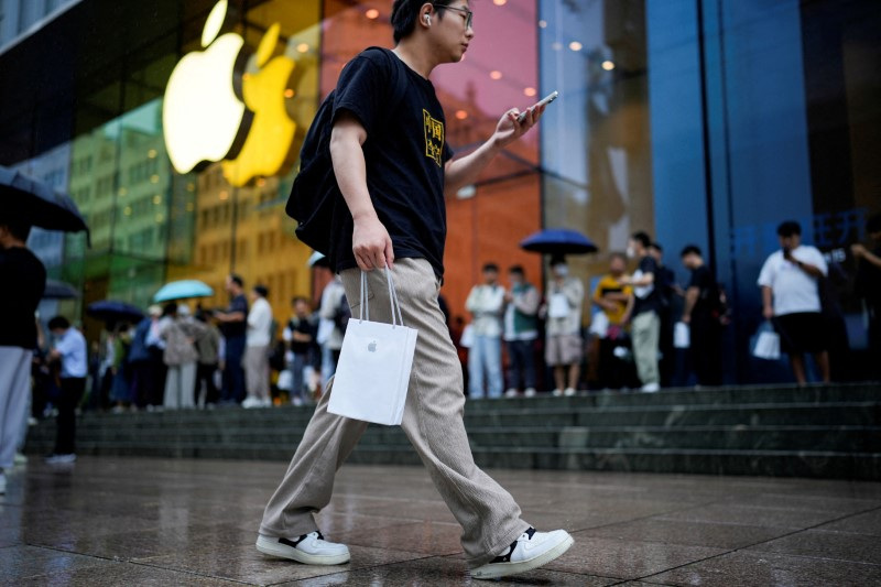 &copy; Reuters. FILE PHOTO: A man holds a bag with a new iPhone inside it in Shanghai, China September 22, 2023. REUTERS/Aly Song/File Photo