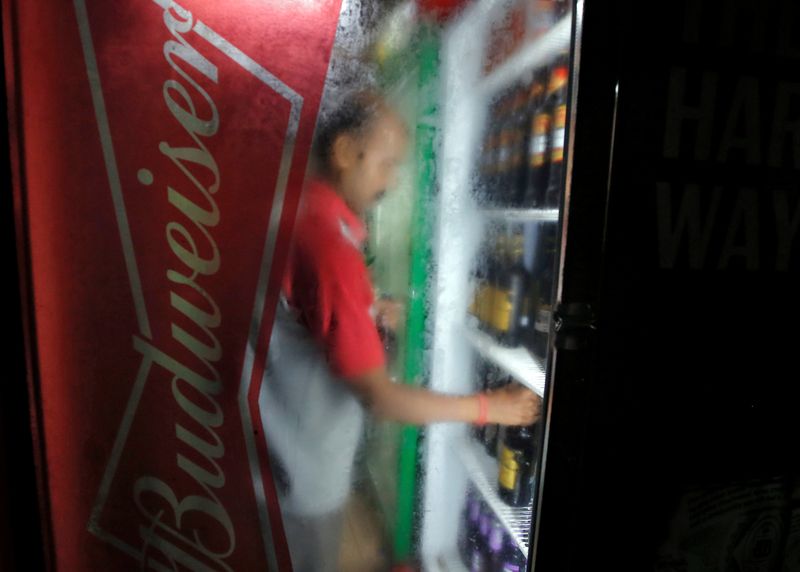 &copy; Reuters. FOTO DE ARCHIVO: Un trabajador ordena botellas de cerveza Budweiser en un refrigerador en una tienda de licores en Calcuta, India. 13 de septiembre de 2019. REUTERS/Rupak De Chowdhuri/Archivo