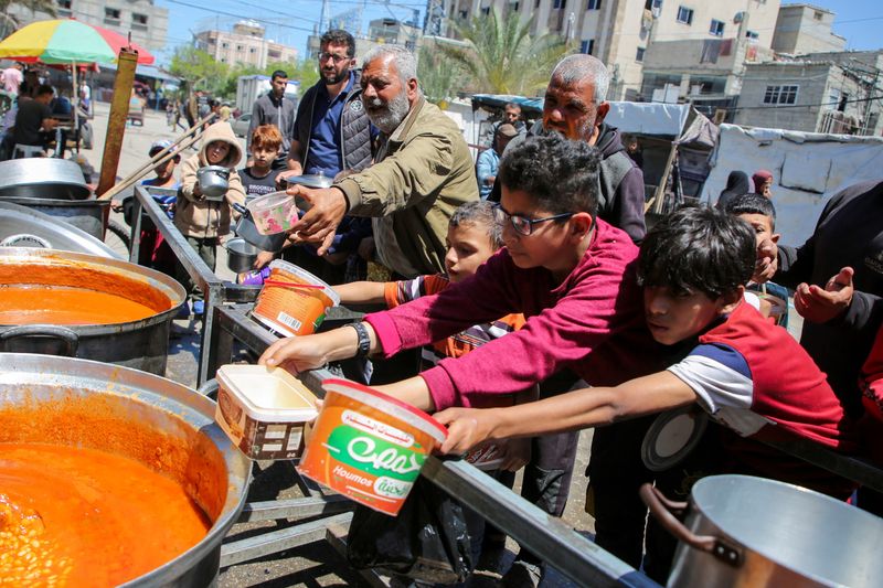 &copy; Reuters. Decenas de palestinos se congregan para recibir comida de una organización humanitaria en Rafah, en la Franja de Gaza. 8 mayo 2024. REUTERS/Hatem Khaled