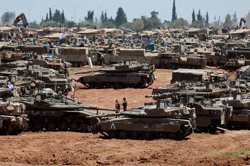 &copy; Reuters. Israeli soldiers walk next to military vehicles near the Israel-Gaza border, amid the ongoing conflict between Israel and the Palestinian Islamist group Hamas, in southern Israel, May 8, 2024. REUTERS/Ammar Awad     TPX IMAGES OF THE DAY