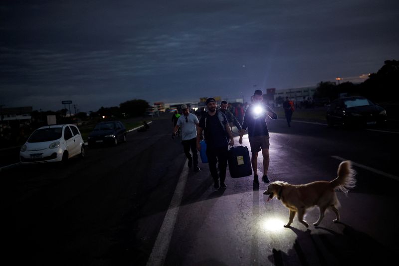&copy; Reuters. Homens carregam combustível por rua alagada de Eldorado do Sul, no Rio Grande do Sul
06/05/2024
REUTERS/Amanda Perobelli