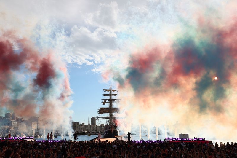 © Reuters. Paris Olympics 2024 - Arrival of the Olympic Flame in Marseille - Marseille, France - May 8, 2024  General view of colored smoke as French rapper Julien Mari is seen after the Olympic Flame was lit at the Old Port ahead of the Paris Olympics 2024 REUTERS/Denis Balibouse