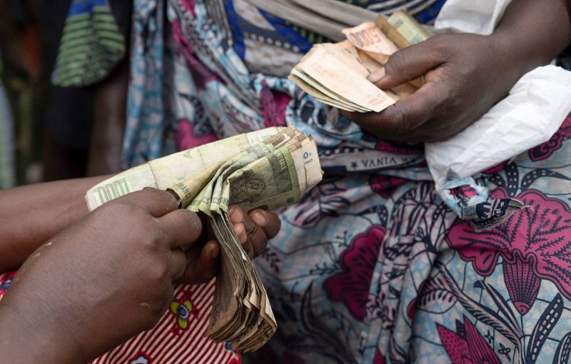 &copy; Reuters. Clementine Musonge, a trader, counts Congolese francs bank notes at the Kituku market in Goma, North Kivu province of the Democratic Republic of Congo February 15, 2024. REUTERS/Arlette Bashizi/File photo