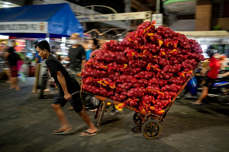 &copy; Reuters. FILE PHOTO: A worker pulls a cart carrying sacks of onions at a public market in Manila, Philippines, January 28, 2023. REUTERS/Lisa Marie David