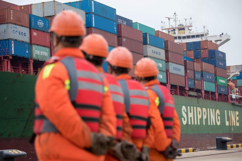 &copy; Reuters. FOTO DE ARCHIVO. Trabajadores observan cómo un buque de carga se acerca a una terminal en el puerto de Qingdao, en la provincia de Shandong, China. 8 de noviembre de 2018. REUTERS/Stringer