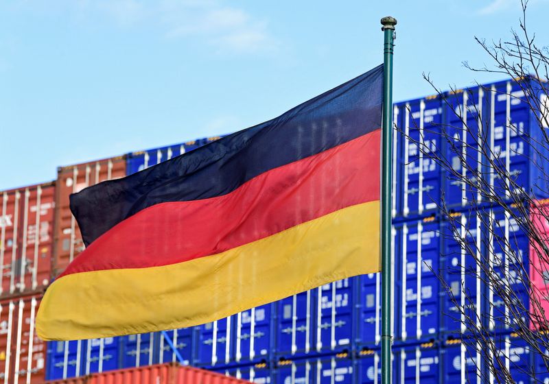 © Reuters. FILE PHOTO: A German flag blows in the wind in front of a stack of containers at the harbour in Hamburg, Germany, February 24, 2022. REUTERS/Fabian Bimmer/File Photo