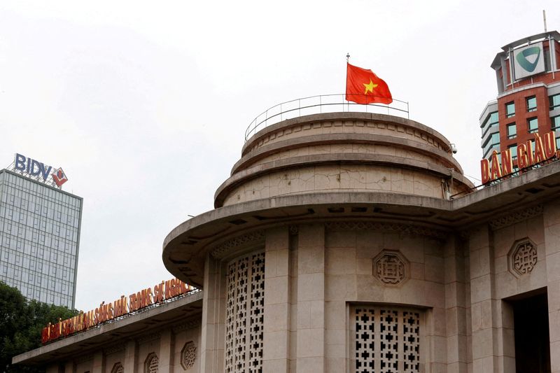 &copy; Reuters. FOTO DE ARCHIVO. Una bandera vietnamita ondea en lo alto del edificio del banco del Estado, cerca de los edificios del Vietcombank y del Banco de Inversión y Desarrollo de Vietnam, en el centro de Hanói, Vietnam. 23 de noviembre de 2017. REUTERS/Kham