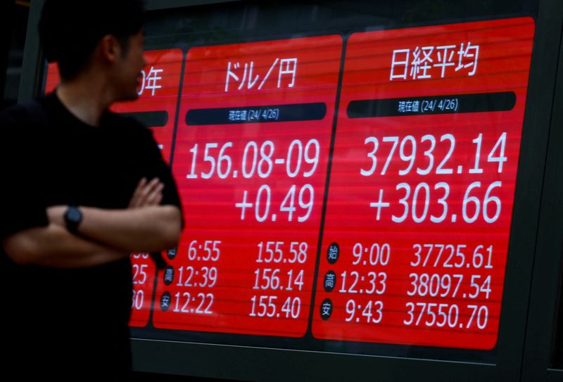 &copy; Reuters. شخص ينظر إلى شاشة تعرض حركة مؤشر نيكي وسعر الين الياباني أمام الدولار الأمريكي في طوكيو يوم 26 أبريل نيسان 2024. تصوير: إيسي كاتو - رويترز