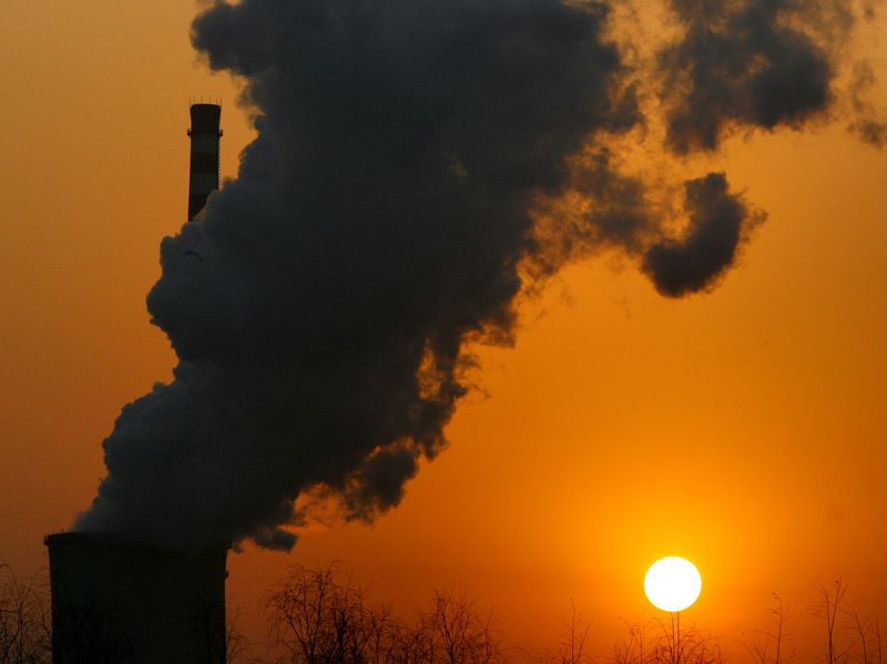 &copy; Reuters. FILE PHOTO: The sun sets next to a smokestack from a coal-burning power station in Beijing January 9, 2008.  REUTERS/David Gray