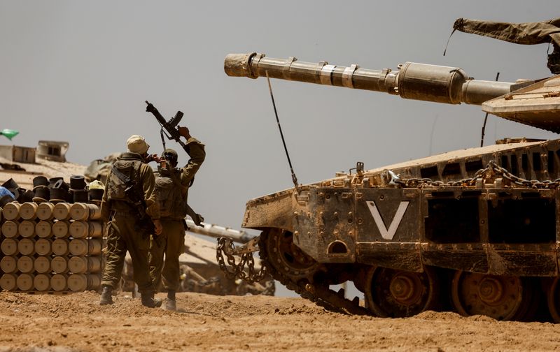 © Reuters. Israeli soldiers walk near a tank, amid the ongoing conflict between Israel and the Palestinian Islamist group Hamas, near the Israel-Gaza Border, in southern Israel, May 9, 2024. REUTERS/Amir Cohen