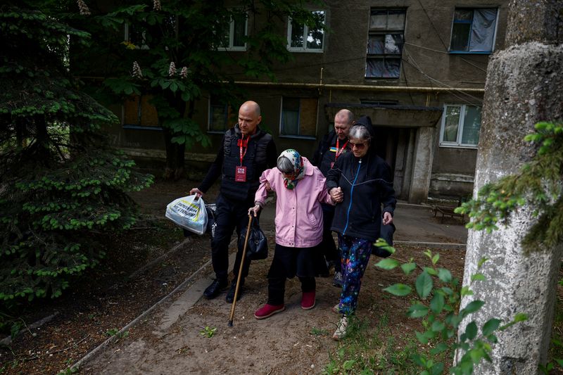 &copy; Reuters. Oleksandr and Vladyslav, volunteers of the EastSOS non-government organisation, assist local resident Valentyna Sharonova, 88-year-old and her daughter Anzhelika, 57-year-old, during their evacuation from the town of Toretsk, amid Russia's attack on Ukrai