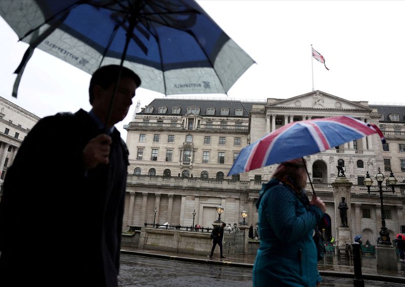 &copy; Reuters. Un turista si ripara dalla pioggia sotto un ombrello con la stampa della bandiera del Regno Unito vicino alla Banca d'Inghilterra nel quartiere finanziario della City of London a Londra, Gran Bretagna, 13 febbraio 2024. Foto REUTERS/Isabel Infantes/File P