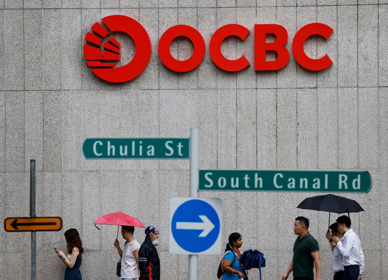 &copy; Reuters. FILE PHOTO: People pass an OCBC Bank signage in Singapore July 11, 2023. REUTERS/Edgar Su/File photo