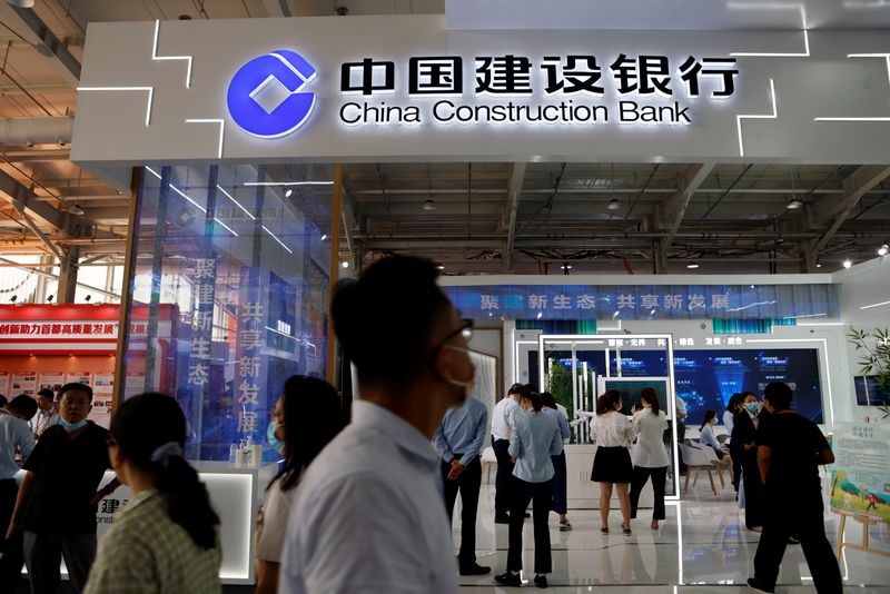 &copy; Reuters. FILE PHOTO: People walk past the China Construction Bank booth at the 2021 China International Fair for Trade in Services (CIFTIS) in Beijing, China September 3, 2021. REUTERS/Florence Lo/File Photo