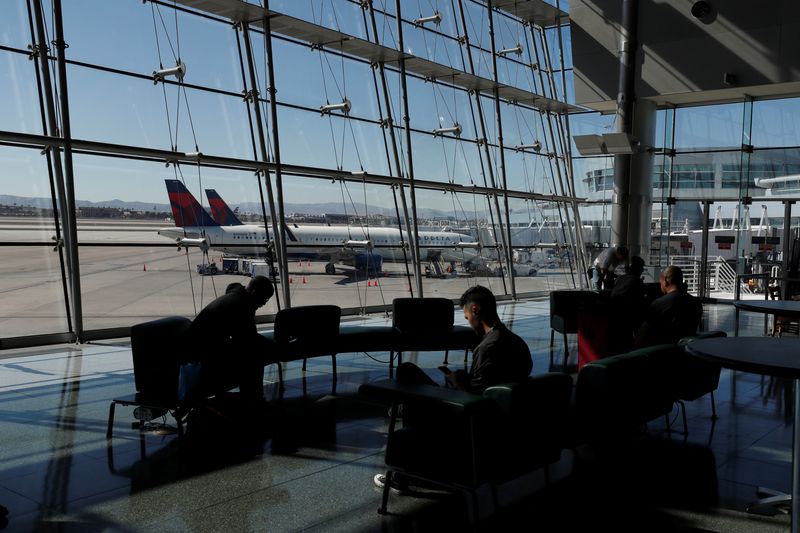 &copy; Reuters. FILE PHOTO: Travelers sit in a lounge area as Delta Air Lines plane park at a gate in McCarran International Airport in Las Vegas, Nevada, U.S., February 14, 2020. Picture taken February 14, 2020.  REUTERS/Shannon Stapleton/File Photo