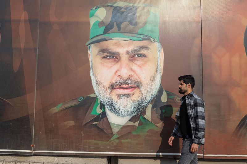 &copy; Reuters. FILE PHOTO: A man walks past a picture of Iraqi Shi'ite cleric Moqtada al-Sadr during Iraq's provincial council elections, in Baghdad, Iraq, December 18, 2023. REUTERS/Ahmed Saad/File Photo