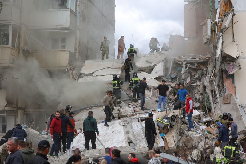 © Reuters. People remove debris while searching for survivors following the collapse of a section of a multi-story apartment block, as the result of what local authorities called a Ukrainian missile strike, in the course of Russia-Ukraine conflict in the city of Belgorod, Russia, May 12, 2024. REUTERS/Stringer