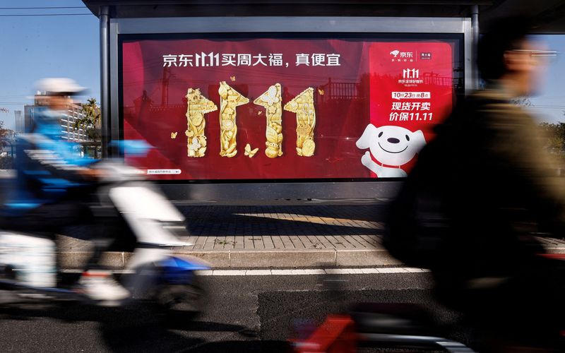 &copy; Reuters. FILE PHOTO: People ride on a scooter past a JD.com's advertisement promoting Singles Day shopping festival, in Beijing, China October 26, 2023. REUTERS/Tingshu Wang/File Photo