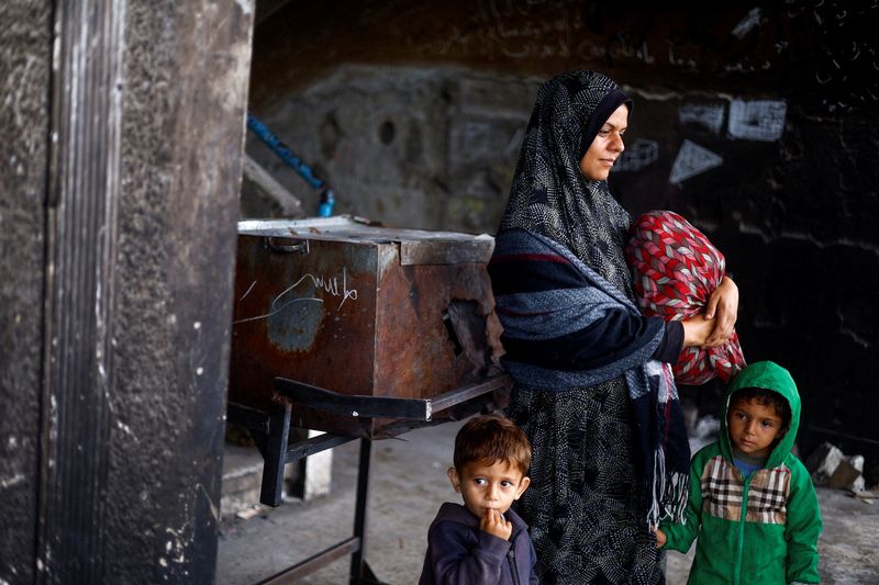 &copy; Reuters. Mulher palestina deslocada Mai Anseir com crianças em escola onde se abrigam enquanto se preparam para fugir de Rafah após forças israelenses lançarem operação terrestre e aérea na cidade 
13/05/2024
REUTERS/Mohammed Salem