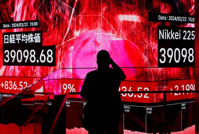 &copy; Reuters. A visitor using his smartphone takes photos of an electronic screen displaying Japan's Nikkei share average, which surged past an all-time record high scaled in December 1989, inside a building in Tokyo, Japan February 22, 2024. REUTERS/Issei Kato/File Ph
