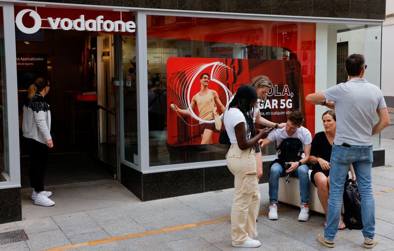 &copy; Reuters. Turisti fanno una pausa accanto a un negozio Vodafone in una via dello shopping a Ronda, Spagna, 2 giugno 2023. REUTERS/Jon Nazca