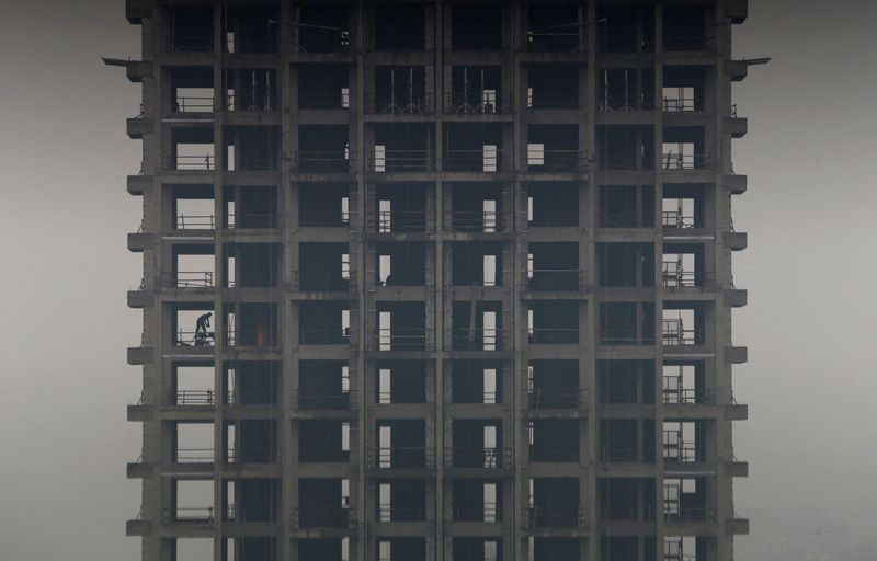 &copy; Reuters. FILE PHOTO: A labourer works on a construction site of a residential building during a hazy day in Hangzhou, Zhejiang province, March 17, 2013. REUTERS/William Hong