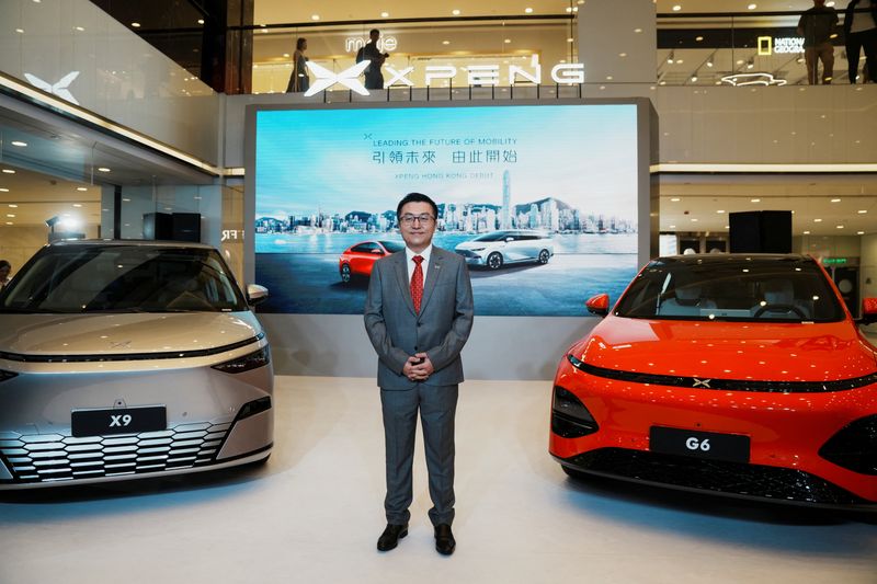 &copy; Reuters. Xpeng Co-President Brian Gu poses for a photograph standing between the Xpeng X9 and G6 vehicles during the company's debut ceremony in Hong Kong, China May 17, 2024. REUTERS/Lam Yik