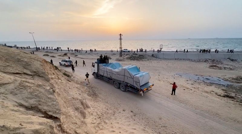 &copy; Reuters. A truck carrying aid delivered into Gaza via a U.S.-built pier moves, as seen from central Gaza Strip, in this still image taken from a video, May 17, 2024. REUTERS/Reuters TV
